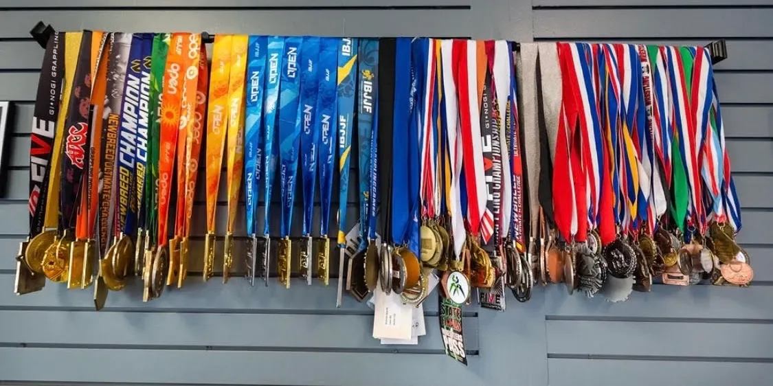 Dozens of championship medals hanging on the wall at Apex House of Grappling