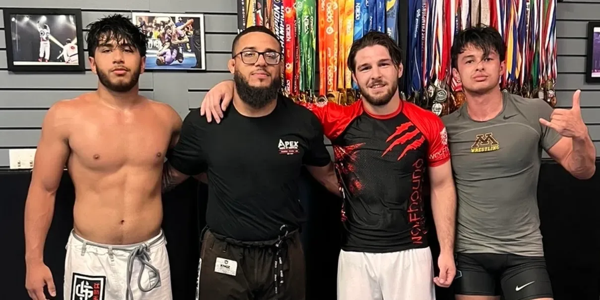 Coach Nick Spacek with three college wrestlers at Apex House of Grappling